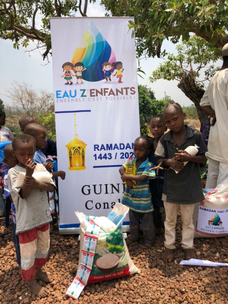Photo d'enfants recevant des denrées alimentaires données par l'association Eau Z'Enfants, pendant le ramadan