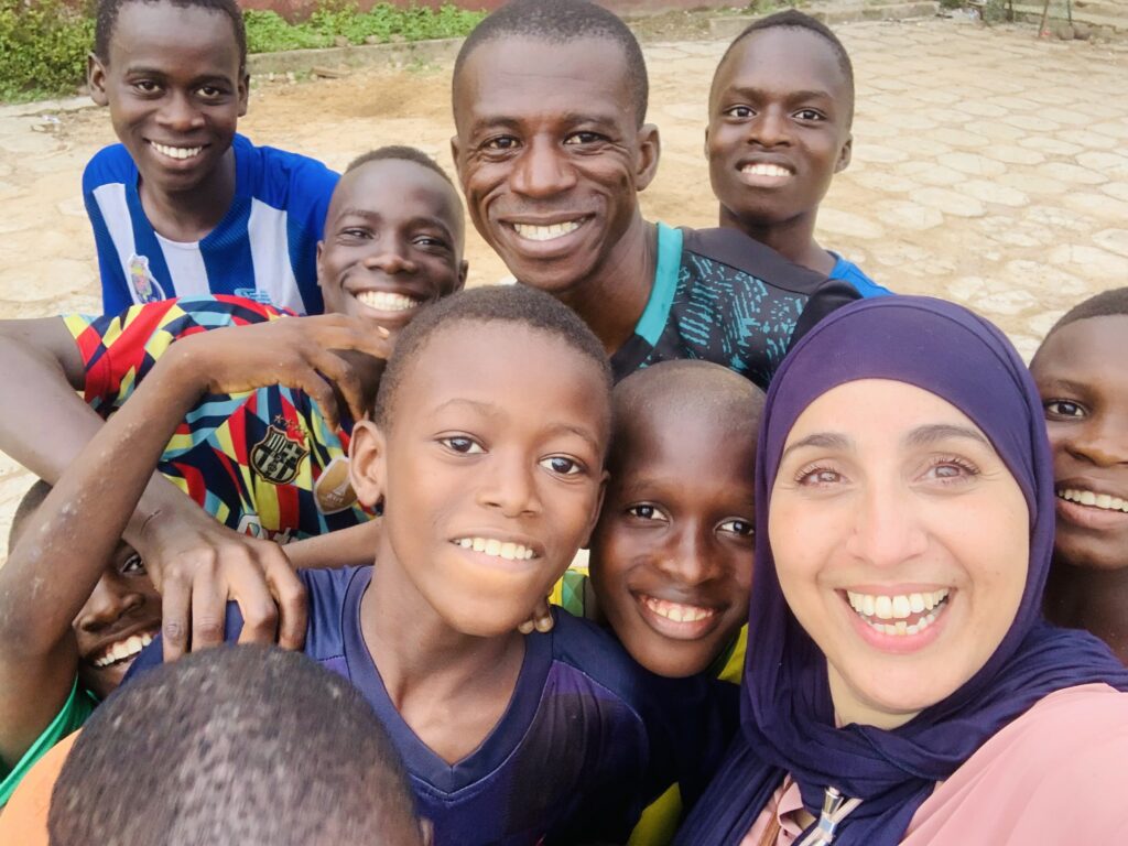 Les enfants de Guinée se réunissent autour de Sabrina, la présidente d’Eau Z’Enfants